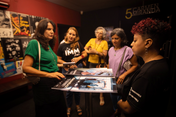 [:pt]2 pôsteres do curta-metragem Humanidade estão sobre uma bancada. 3 mulheres ao redor estão retirando seus pôsteres. 2 profissionais da ImageMagica entregam para elas. Ao fundo, há uma montagem de pôsteres de diferentes filmes.[:]